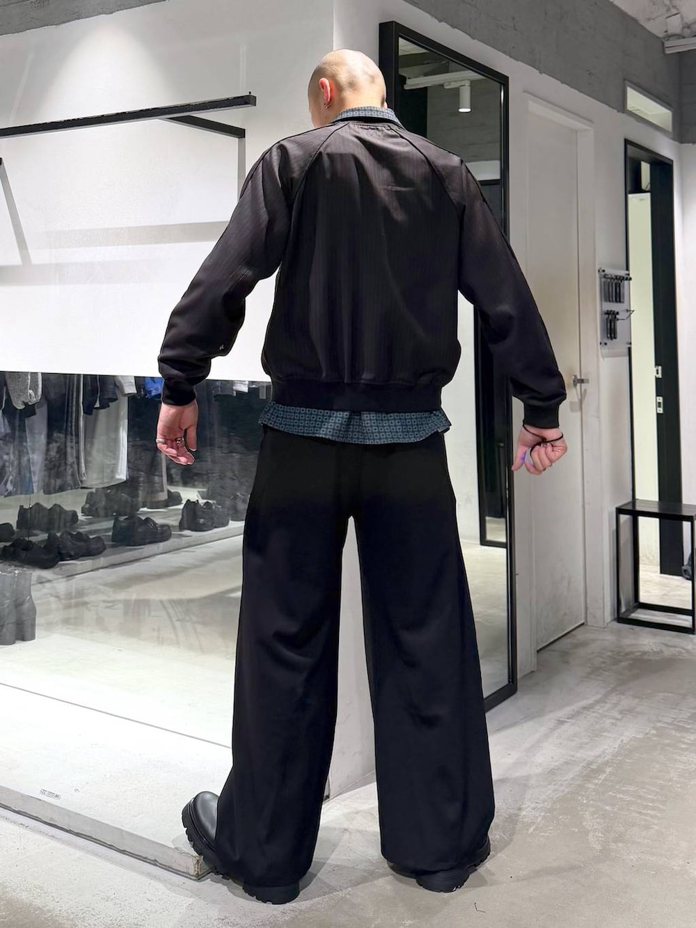 ブラック系のドレスシューズ、ブラック系のスラックス、ブラウン系のその他トップスを着用したメンズの春コーディネートの3枚目の写真