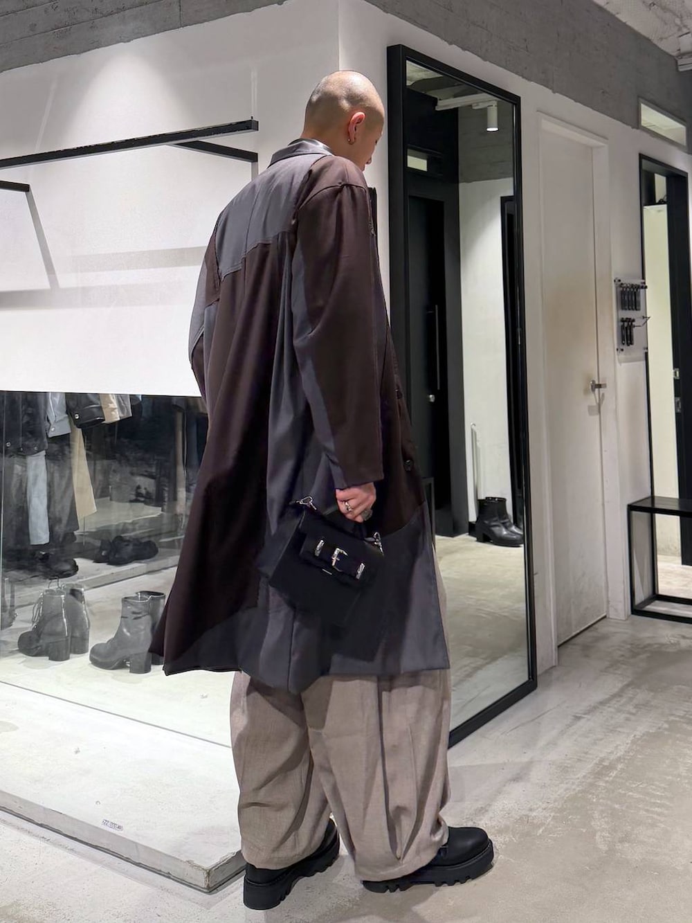 ブラック系のドレスシューズ、ブラック系のハンドバッグ、ブラック系のカーディガン/ボレロを着用したメンズの冬コーディネートの4枚目の写真