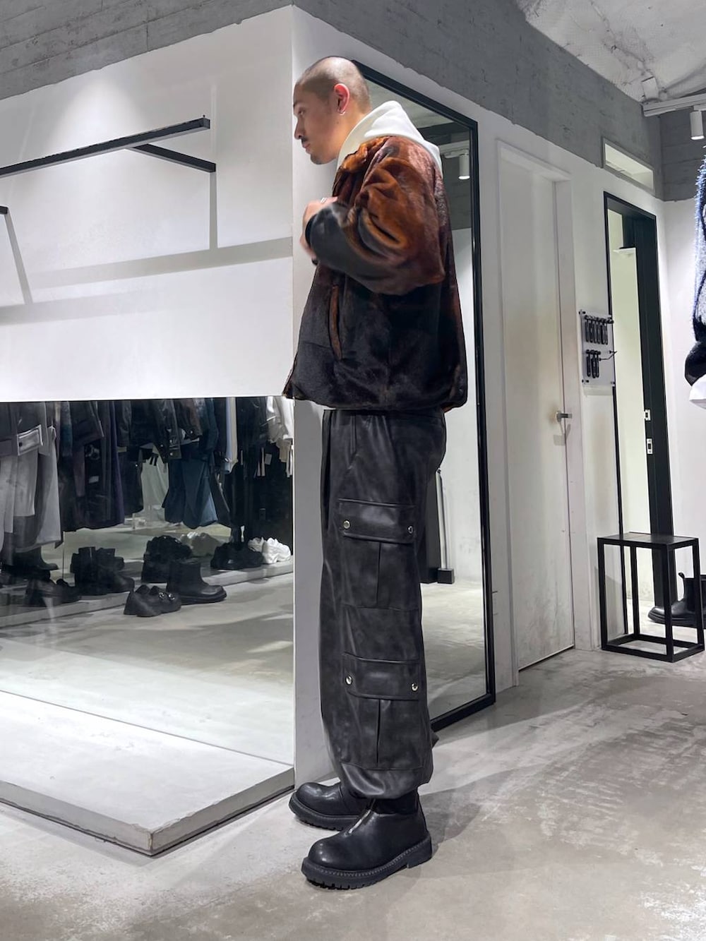 オレンジ系のブルゾン、グレー系のカーゴパンツ、ブラック系のブーツを着用したメンズの秋コーディネートの2枚目の写真