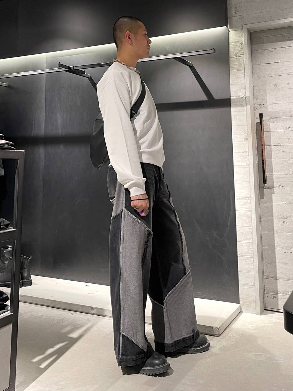 ブラック系のブーツ、ブラック系のショルダーバッグ、シルバー系のネックレスを着用したメンズの秋コーディネートの4枚目の写真