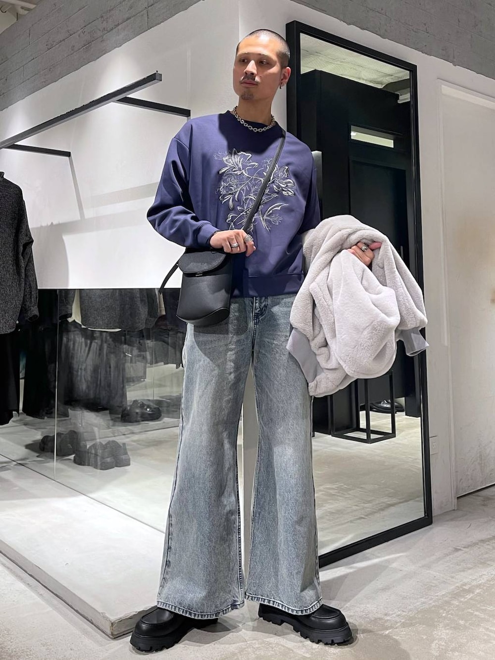 グレー系のブルゾン、ブルー系のデニムパンツ、ブラック系のドレスシューズを着用したメンズの冬コーディネートの5枚目の写真