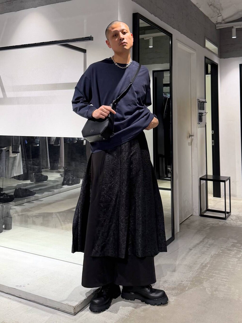 ブラック系のその他パンツ、ブラック系のドレスシューズ、グリーン系のトレンチコートを着用したメンズの春コーディネートの5枚目の写真