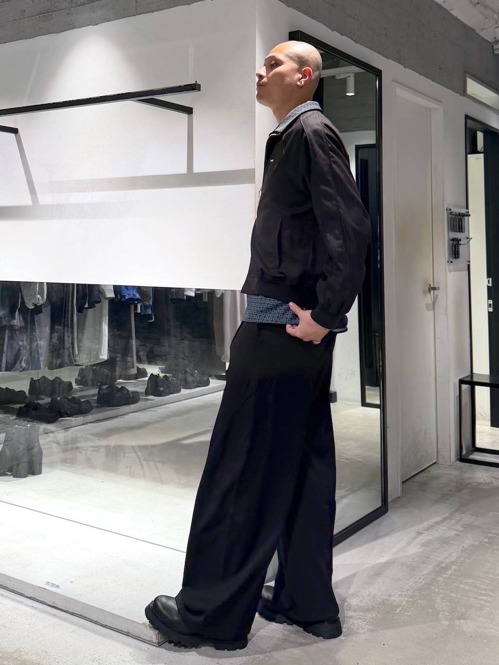 ブラック系のドレスシューズ、ブラック系のスラックス、ブラウン系のその他トップスを着用したメンズの春コーディネートの2枚目の写真