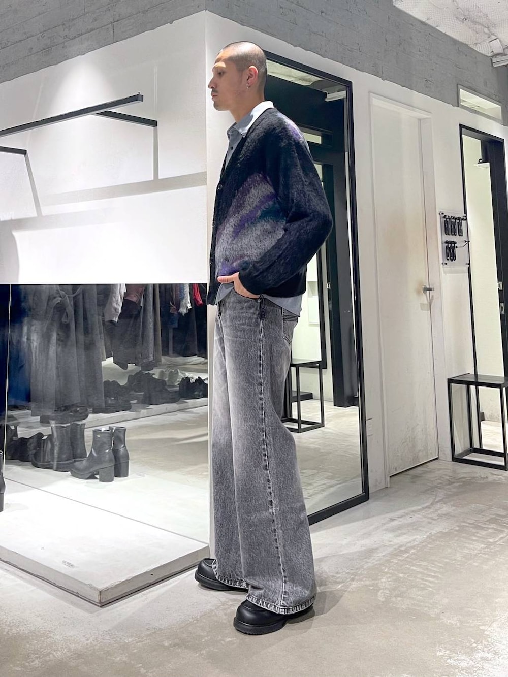 グレー系のデニムパンツ、ブラック系のローファー、ブラック系のショルダーバッグを着用したメンズの冬コーディネートの2枚目の写真