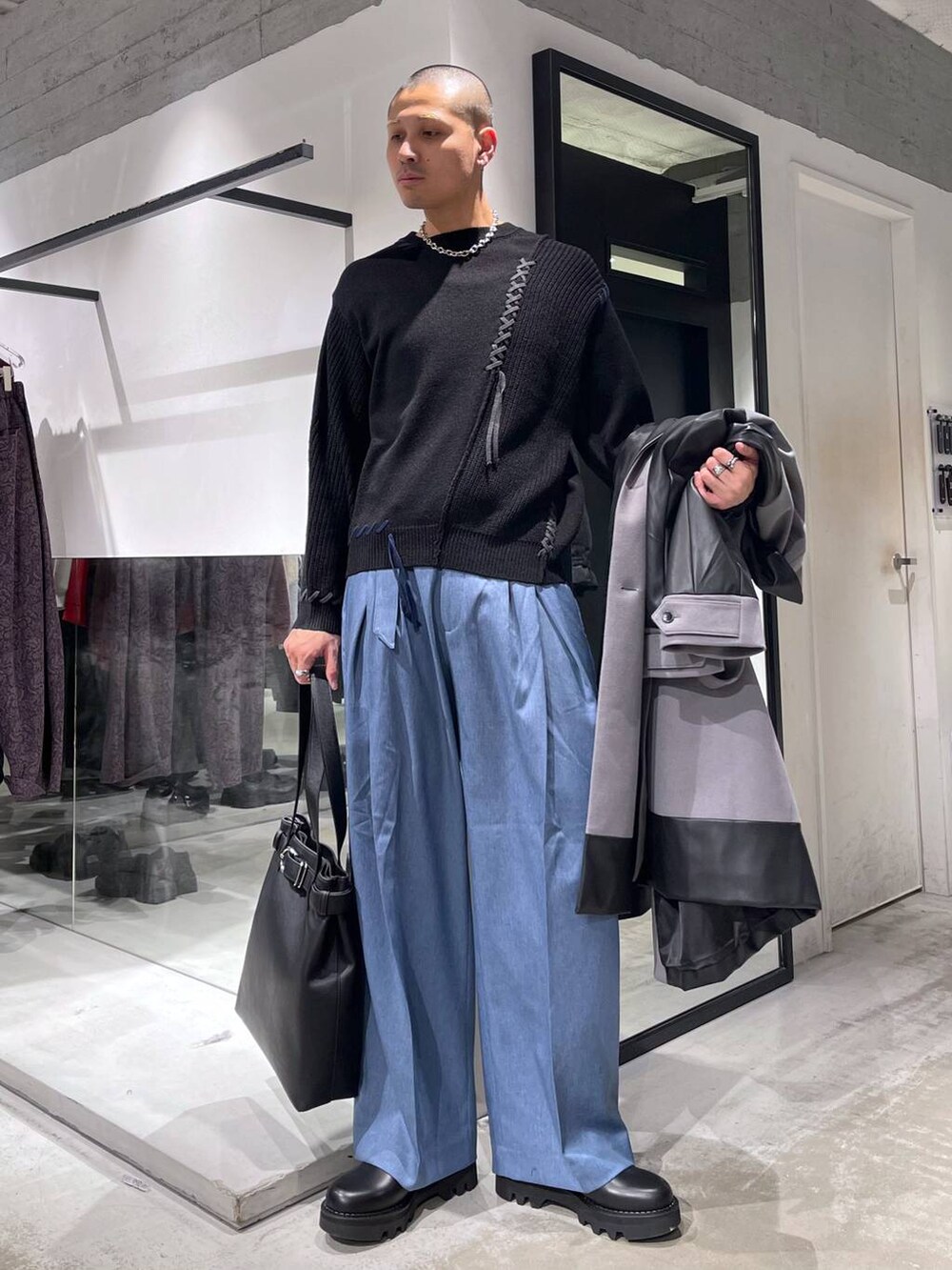 グレー系のトレンチコート、ブラック系のトートバッグ、ブラック系のニット/セーターを着用したメンズの冬コーディネートの5枚目の写真