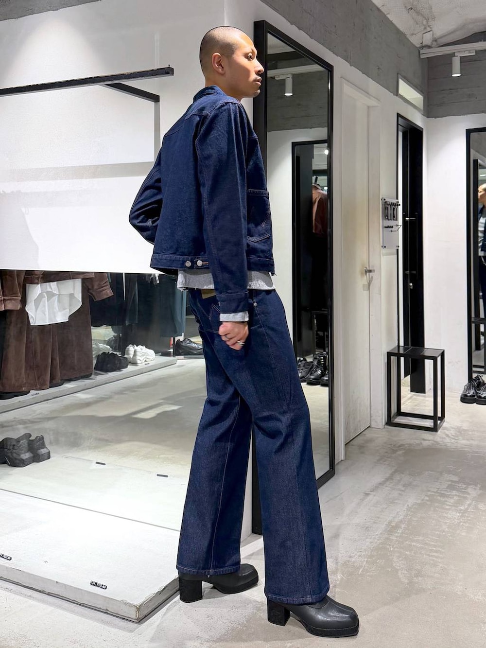 グレー系のTシャツ/カットソー、ブラック系のブーツ、ブルー系のデニムジャケットを着用したメンズの秋コーディネートの4枚目の写真
