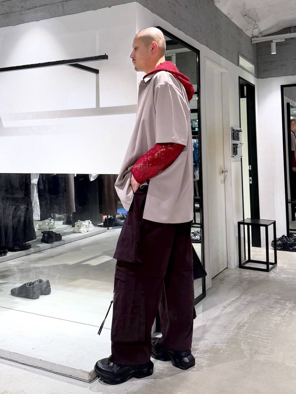 ブラック系のトートバッグ、ブラック系のスニーカー、ブラウン系のカーゴパンツを着用したメンズの春コーディネートの2枚目の写真