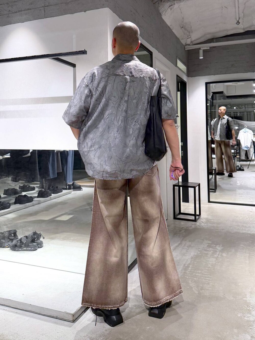 ホワイト系のTシャツ/カットソー、ブラック系のドレスシューズ、ブラック系のトートバッグを着用したメンズの春コーディネートの3枚目の写真