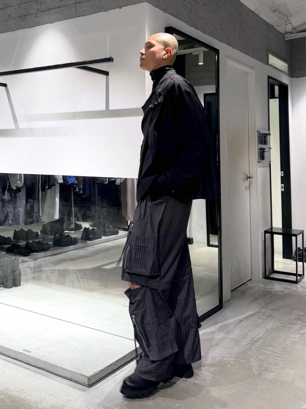 ブラック系のハンドバッグ、ブラック系のドレスシューズ、グレー系のカーゴパンツを着用したメンズの冬コーディネートの3枚目の写真