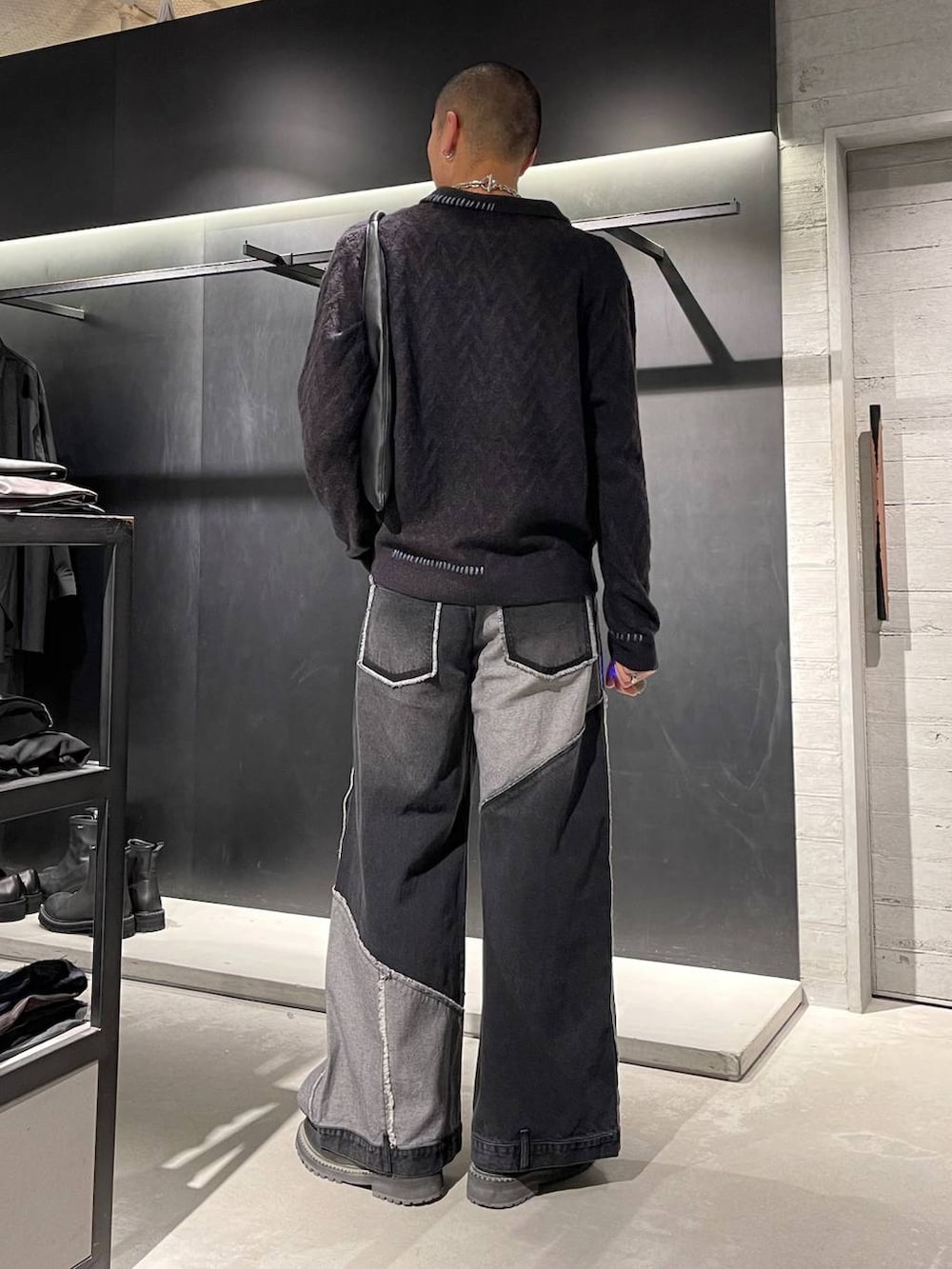 ブラック系のトートバッグ、ブラック系のブーツ、ブラック系のニット/セーターを着用したメンズの秋コーディネートの3枚目の写真