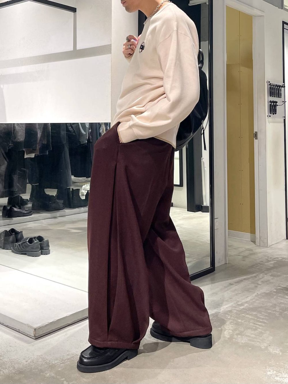 ブラック系のローファー、ブラック系のバックパック/リュック、ホワイト系のニット/セーターを着用したメンズの秋コーディネートの2枚目の写真