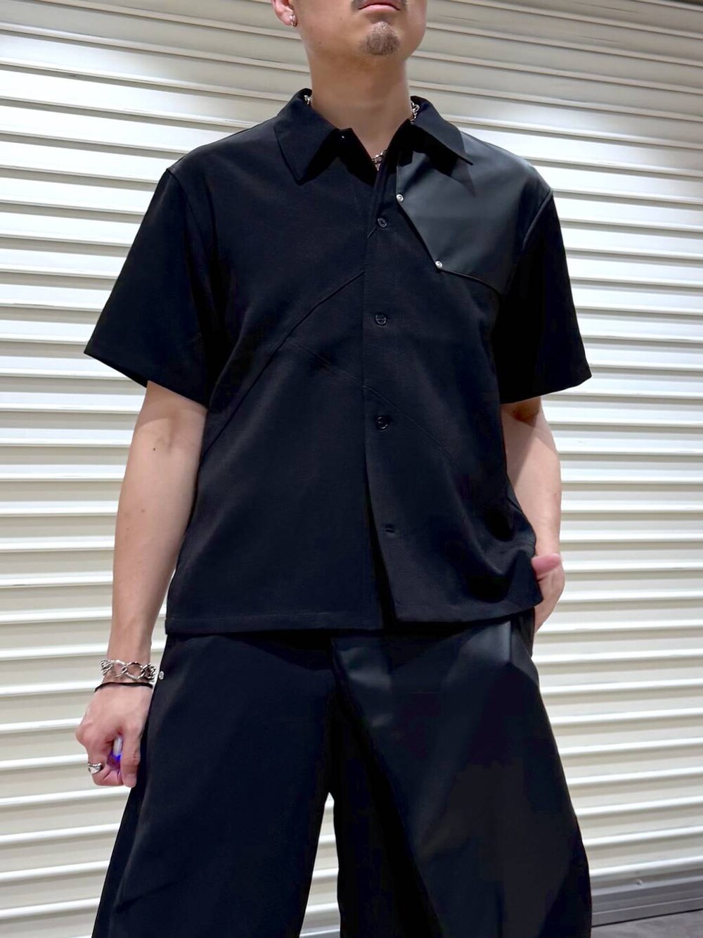 ブラック系のスラックス、ブラック系のシャツ/ブラウス、ブラック系のスニーカーを着用したメンズの夏コーディネートの5枚目の写真