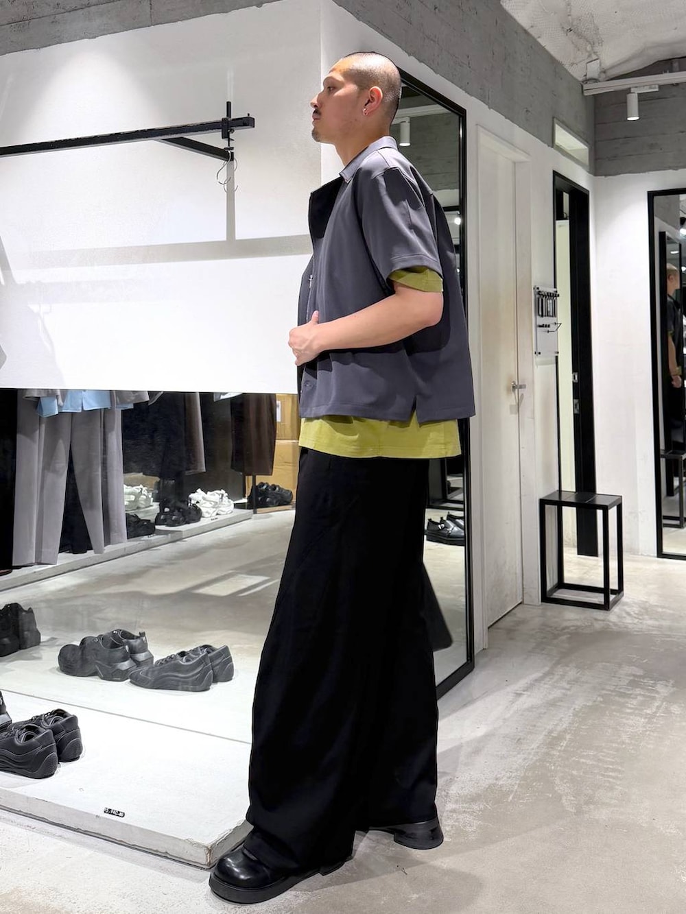 イエロー系のTシャツ/カットソー、ブラック系のトートバッグ、ブラック系のスラックスを着用したメンズの夏コーディネートの2枚目の写真