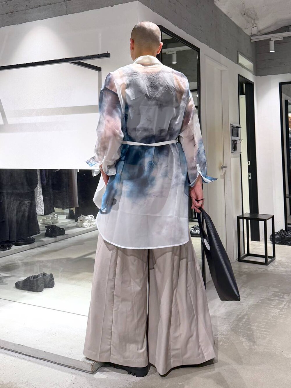 ブラック系のトートバッグ、ブラック系のドレスシューズ、ベージュ系のスラックスを着用したメンズの春コーディネートの3枚目の写真
