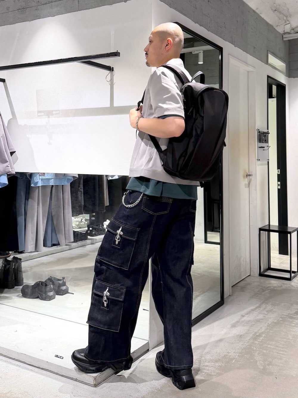 ブラック系のスニーカー、ブラック系のバックパック/リュック、ブルー系のデニムパンツを着用したメンズの夏コーディネートの2枚目の写真