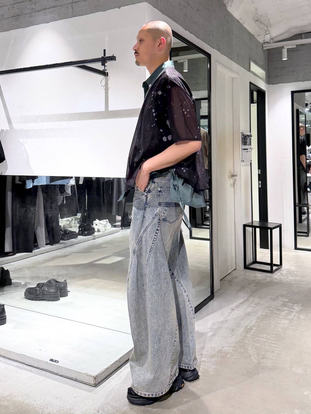ブルー系のデニムパンツ、ブラック系のサンダル、ブラック系のショルダーバッグを着用したメンズの夏コーディネートの2枚目の写真