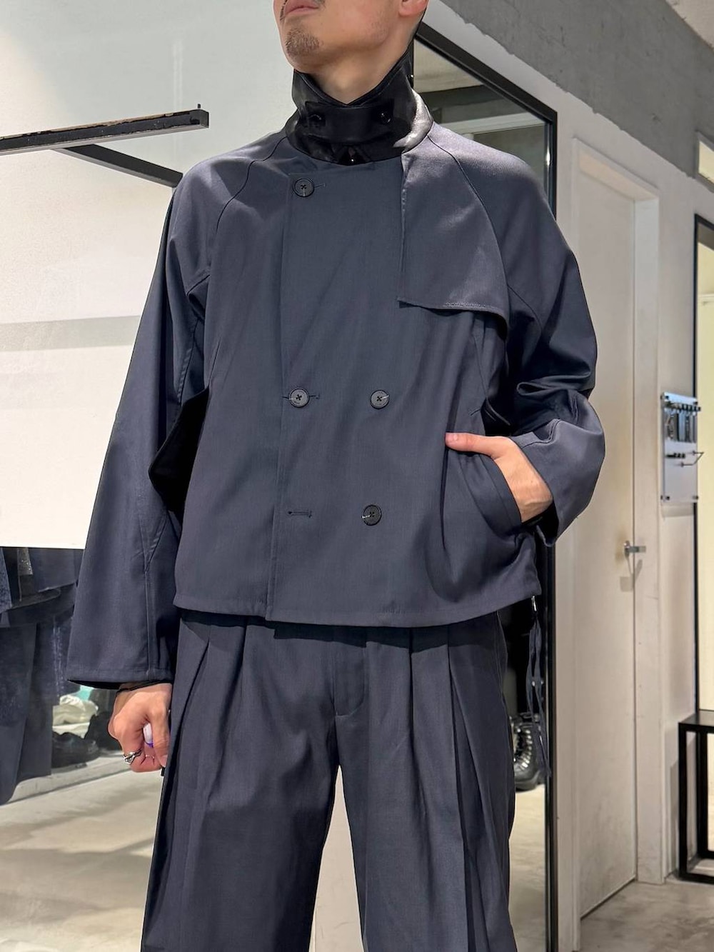 ブラック系のポロシャツ、ブルー系のスラックス、ブルー系のブルゾンを着用したメンズの秋コーディネートの5枚目の写真