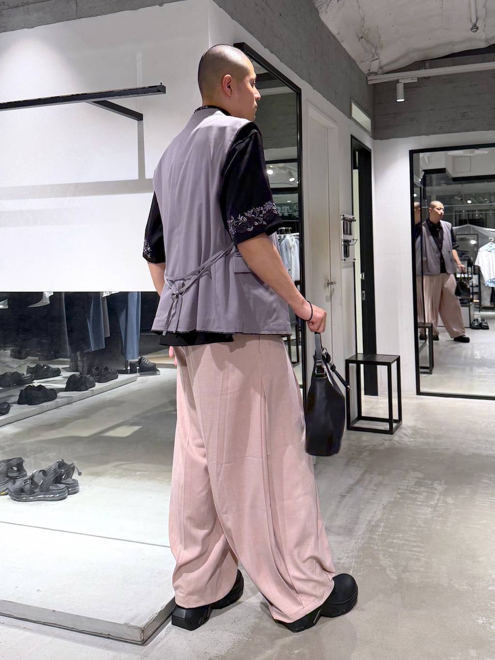 ブラック系のシャツ/ブラウス、ブラック系のドレスシューズ、ブラウン系のベストを着用したメンズの春コーディネートの4枚目の写真