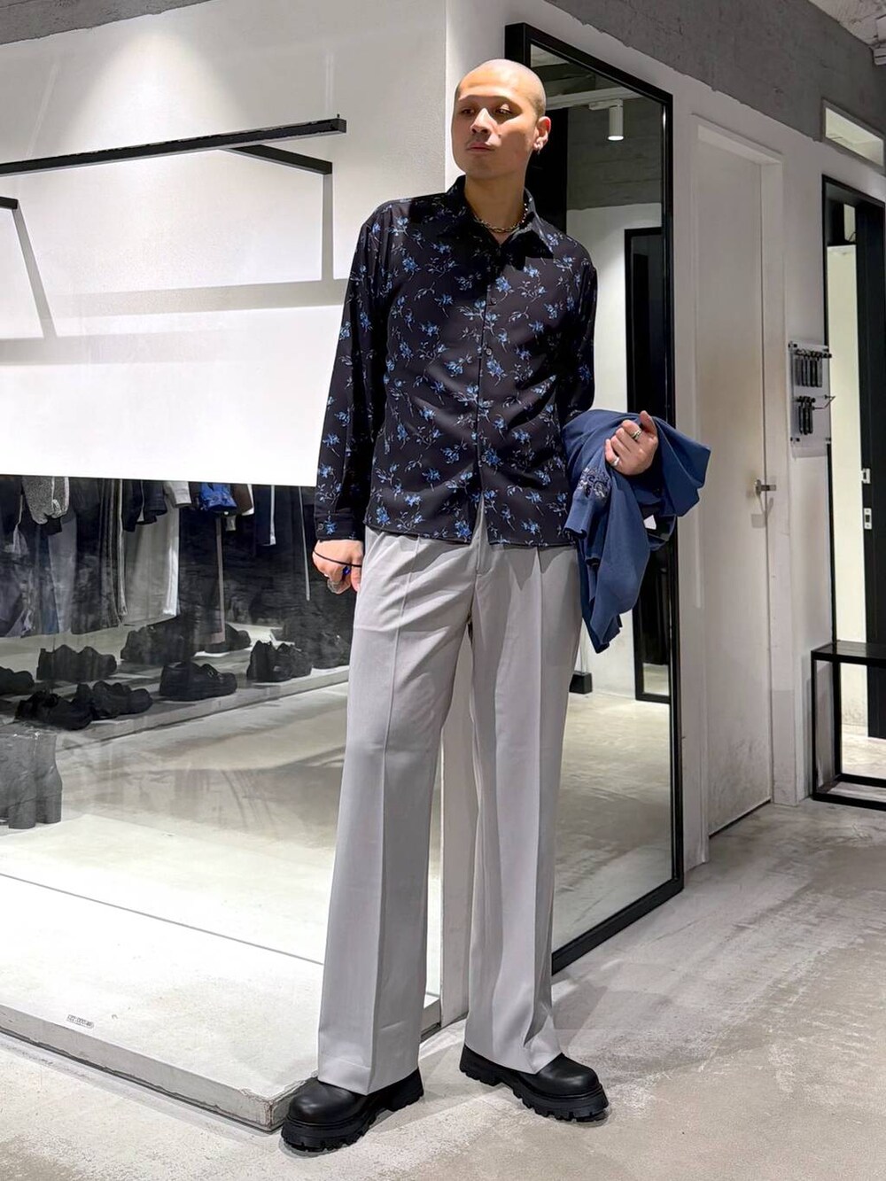 グレー系のスラックス、ブルー系のポロシャツ、ブラック系のドレスシューズを着用したメンズの春コーディネートの5枚目の写真