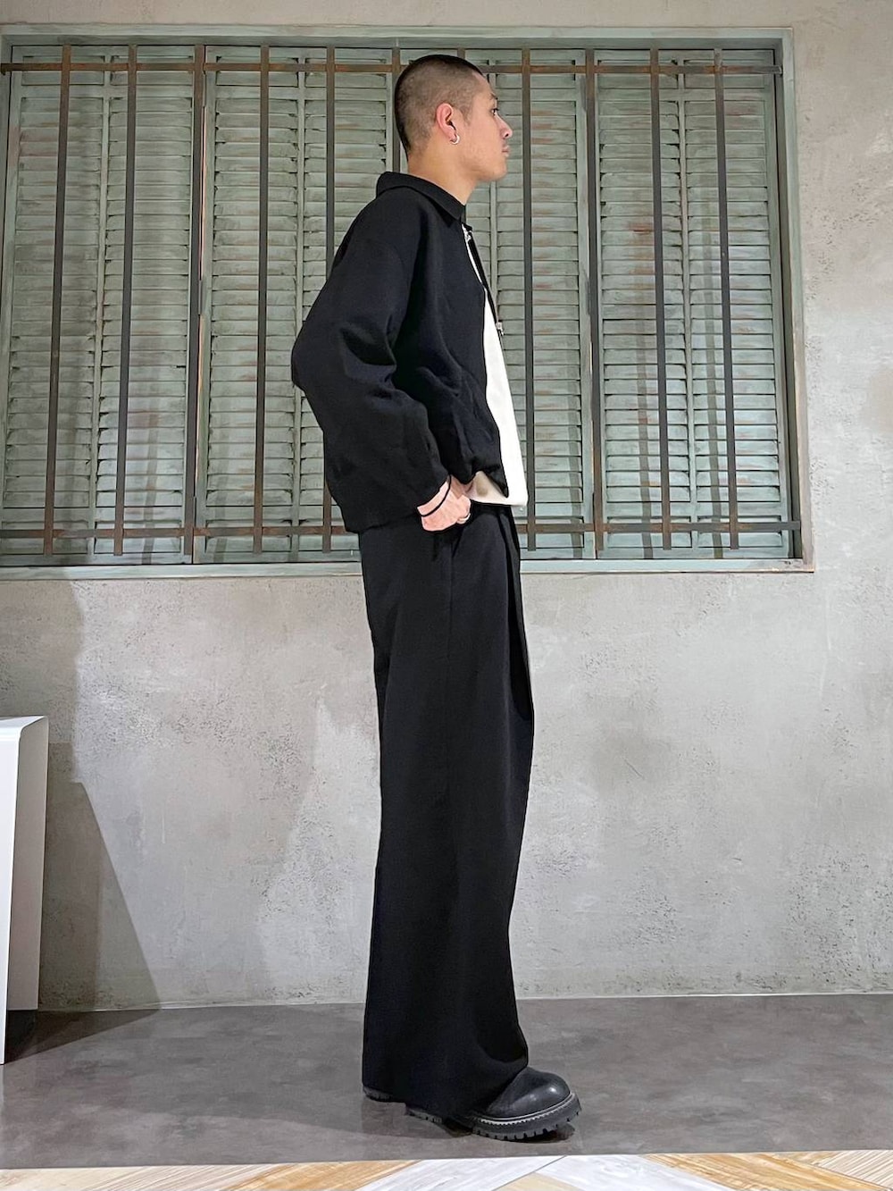 ブラック系のブーツ、ホワイト系のニット/セーター、シルバー系のネックレスを着用したメンズの秋コーディネートの4枚目の写真