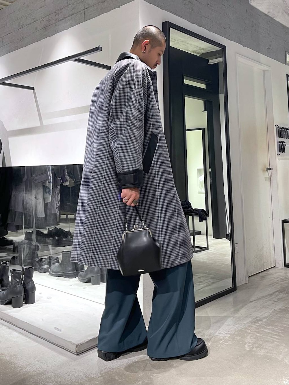 ホワイト系のネクタイ、ベージュ系のステンカラーコート、ブラック系のショルダーバッグを着用したメンズの秋コーディネートの5枚目の写真