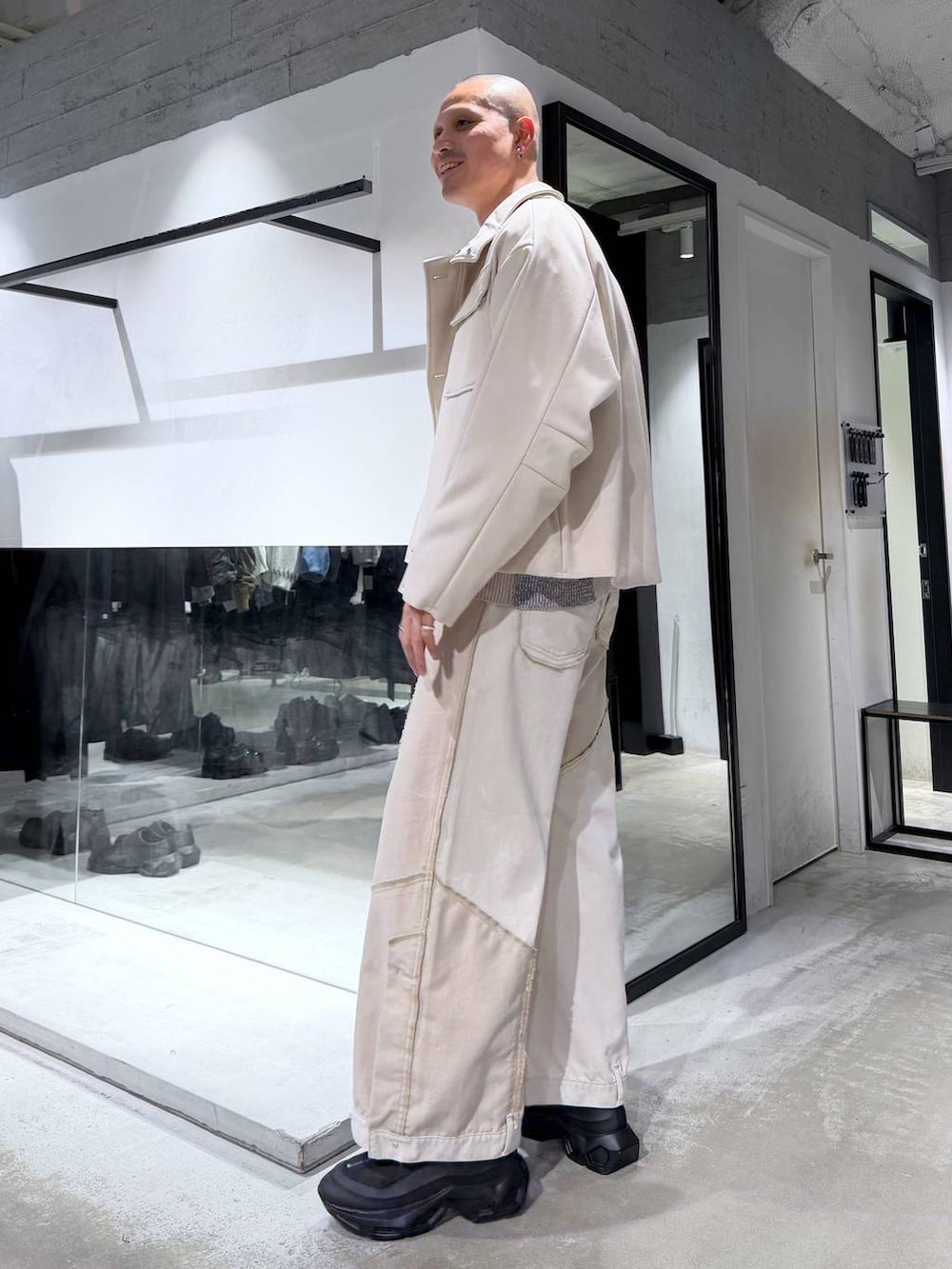 グレー系のカーディガン/ボレロ、ブラック系のブーツ、ホワイト系のブルゾンを着用したメンズの冬コーディネートの2枚目の写真