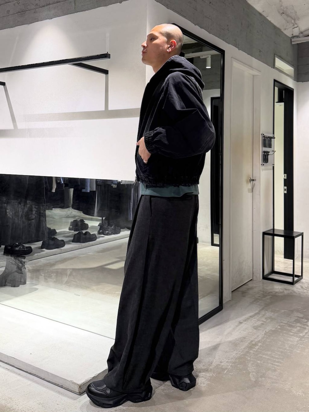 ブラック系のスニーカー、ブラック系のブルゾン、ブラック系のスラックスを着用したメンズの春コーディネートの2枚目の写真