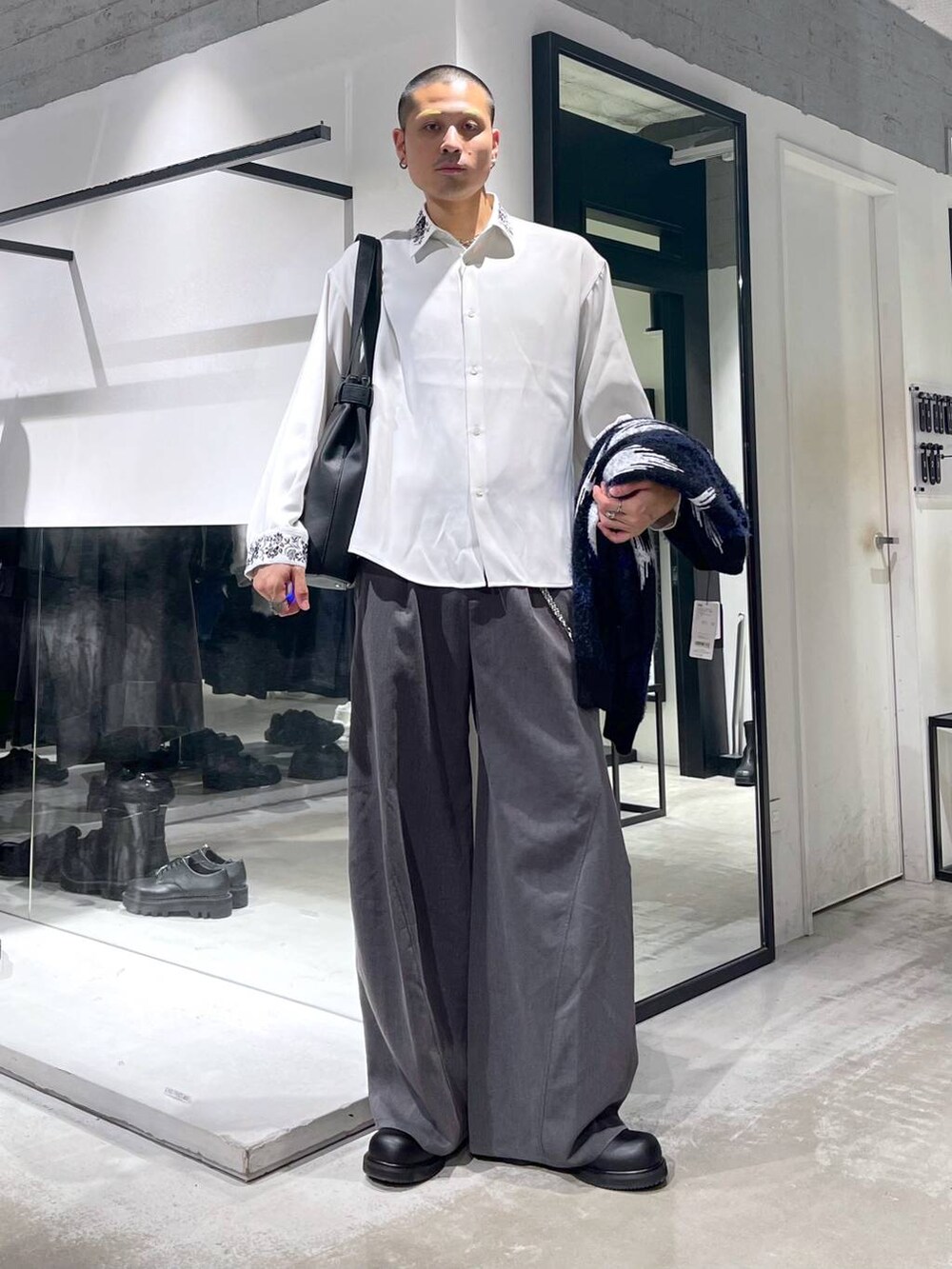 ブラック系のブルゾン、ブラック系のトートバッグ、グレー系のスラックスを着用したメンズの秋コーディネートの6枚目の写真