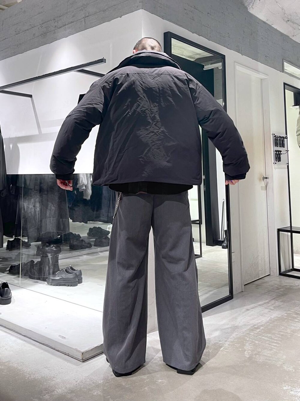 ブラック系のダウンジャケット/コート、グレー系のスラックス、ブラック系のドレスシューズを着用したメンズの冬コーディネートの4枚目の写真