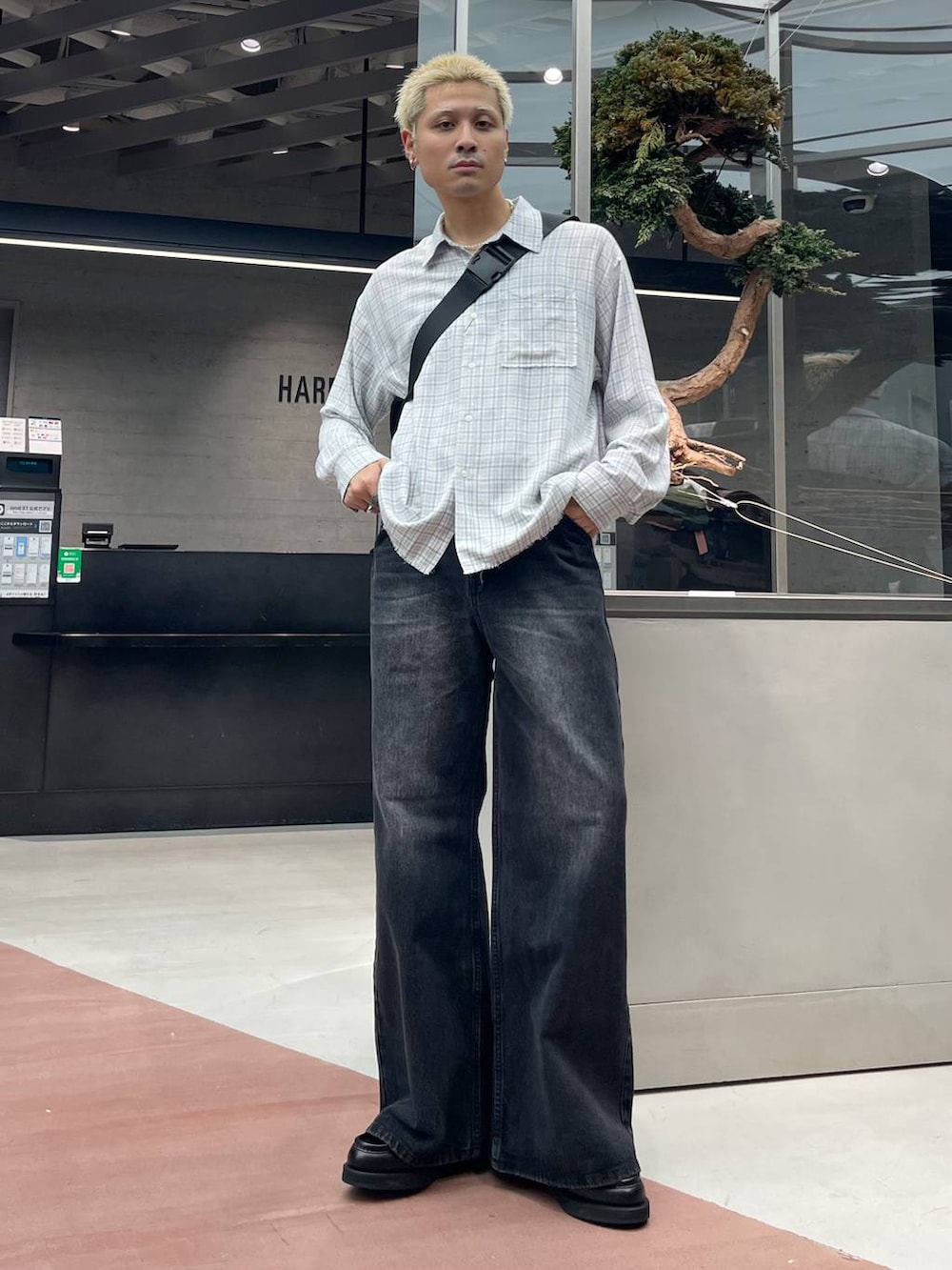 ブラック系のメッセンジャーバッグ、ブラック系のローファー、ブラック系のデニムパンツを着用したメンズの秋コーディネートの2枚目の写真