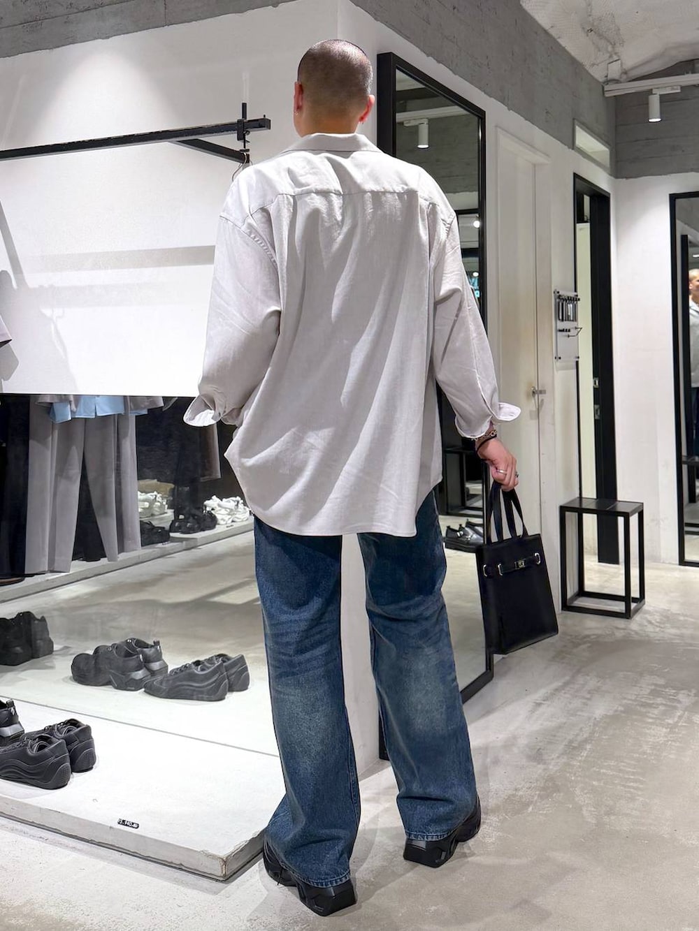 グレー系のシャツ/ブラウス、ブラック系のスニーカー、ブルー系のデニムパンツを着用したメンズの夏コーディネートの3枚目の写真