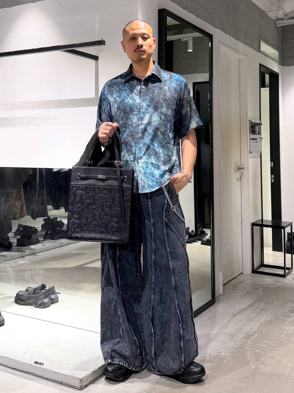 ブラック系のスニーカー、ブルー系のデニムパンツ、ブルー系のシャツ/ブラウスを着用したメンズの夏コーディネートの5枚目の写真