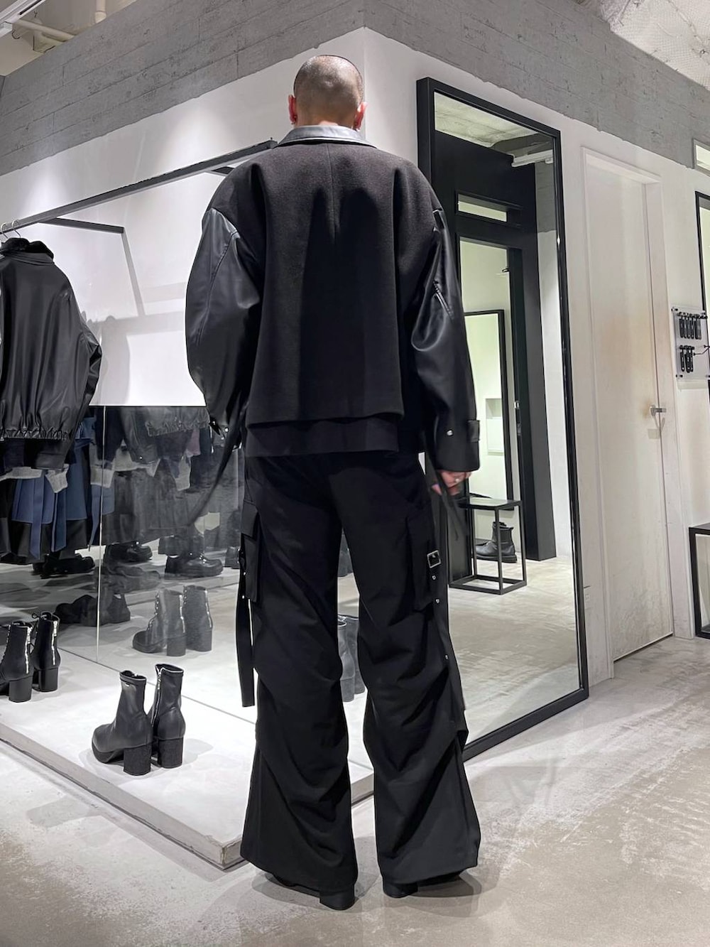 ブラック系のブルゾン、ブラック系のブーツ、ブラック系のカーゴパンツを着用したメンズの冬コーディネートの3枚目の写真