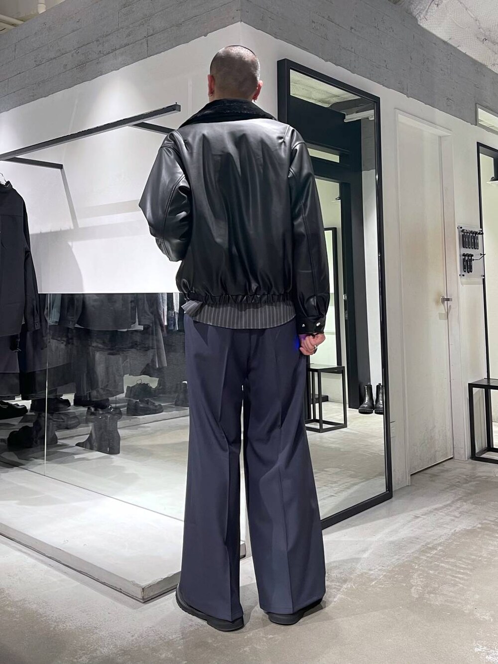 ブラック系のブルゾン、ブルー系のスラックス、ブラック系のショルダーバッグを着用したメンズの冬コーディネートの3枚目の写真