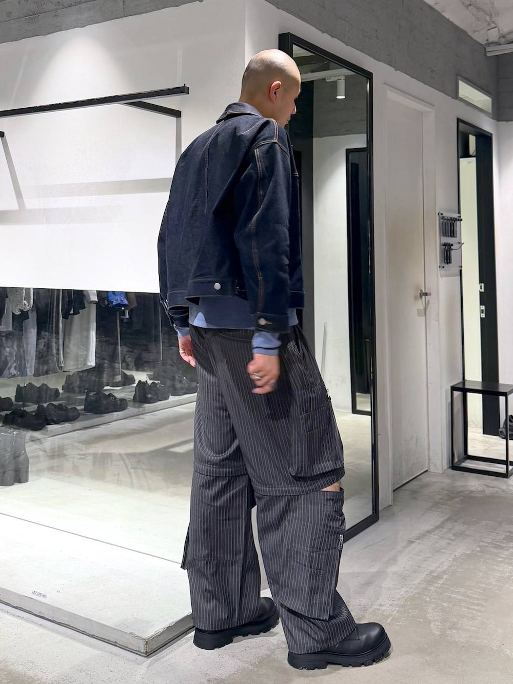 ブルー系のデニムジャケット、ブラック系のドレスシューズ、グレー系のカーゴパンツを着用したメンズの春コーディネートの4枚目の写真