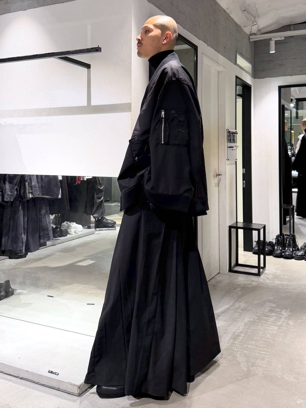ブラック系のブルゾン、ブラック系のTシャツ/カットソー、ブラック系のブーツを着用したメンズの秋コーディネートの2枚目の写真