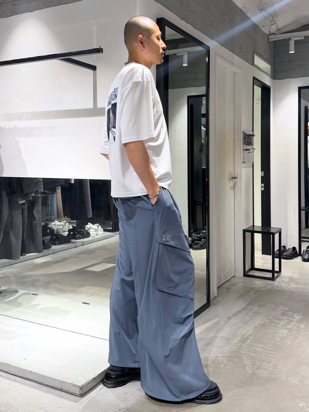 ホワイト系のTシャツ/カットソー、ブルー系のカーゴパンツ、ブラック系のサンダルを着用したメンズの夏コーディネートの4枚目の写真