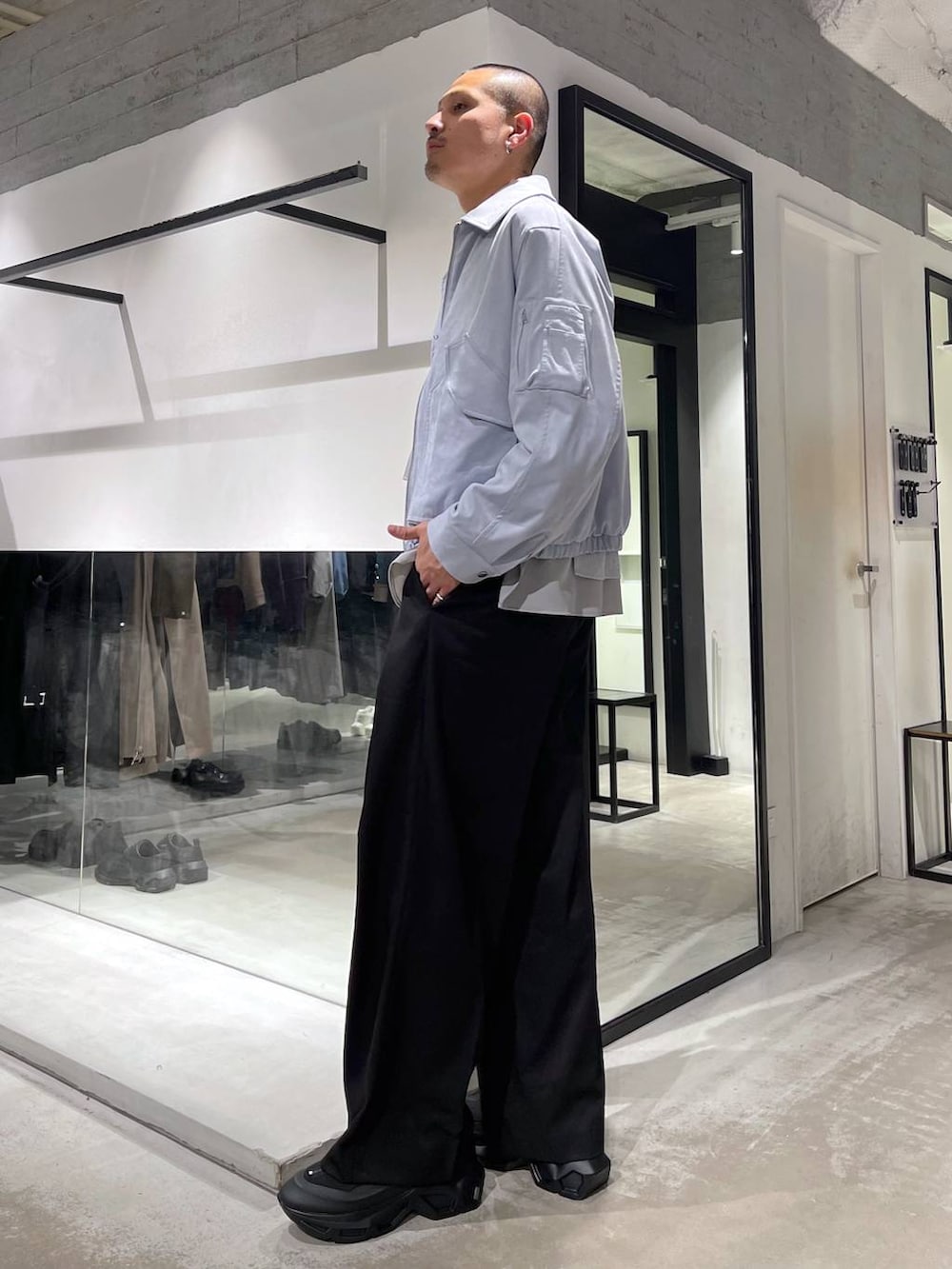 ブラック系のトートバッグ、ブルー系のブルゾン、グレー系のシャツ/ブラウスを着用したメンズの冬コーディネートの2枚目の写真