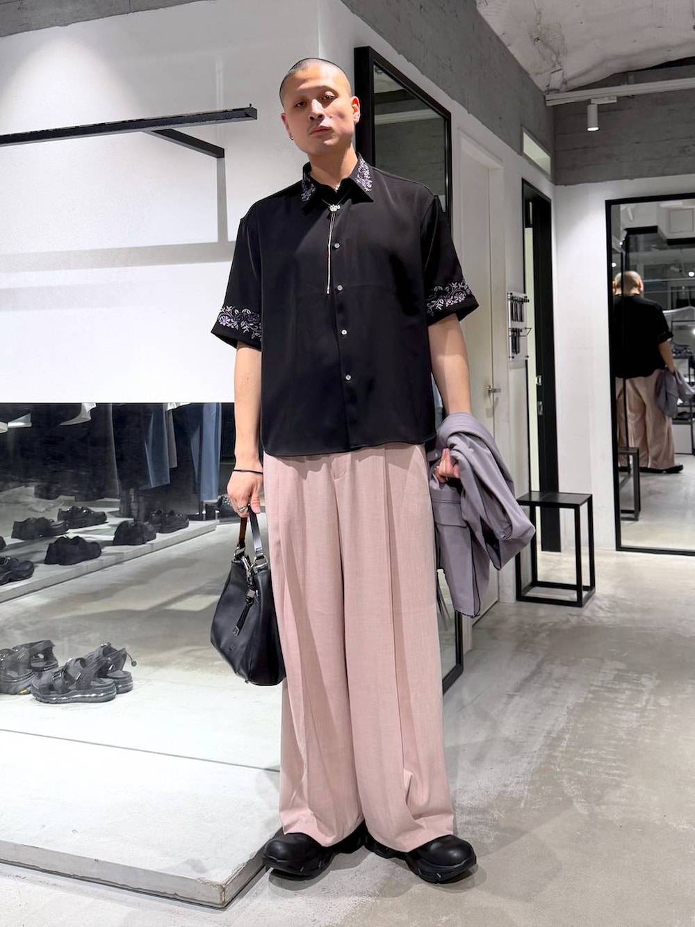 ブラック系のシャツ/ブラウス、ブラック系のドレスシューズ、ブラウン系のベストを着用したメンズの春コーディネートの5枚目の写真