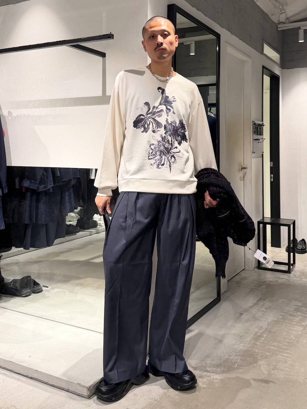 ブルー系のスラックス、ブラック系のローファー、ホワイト系のTシャツ/カットソーを着用したメンズの秋コーディネートの4枚目の写真