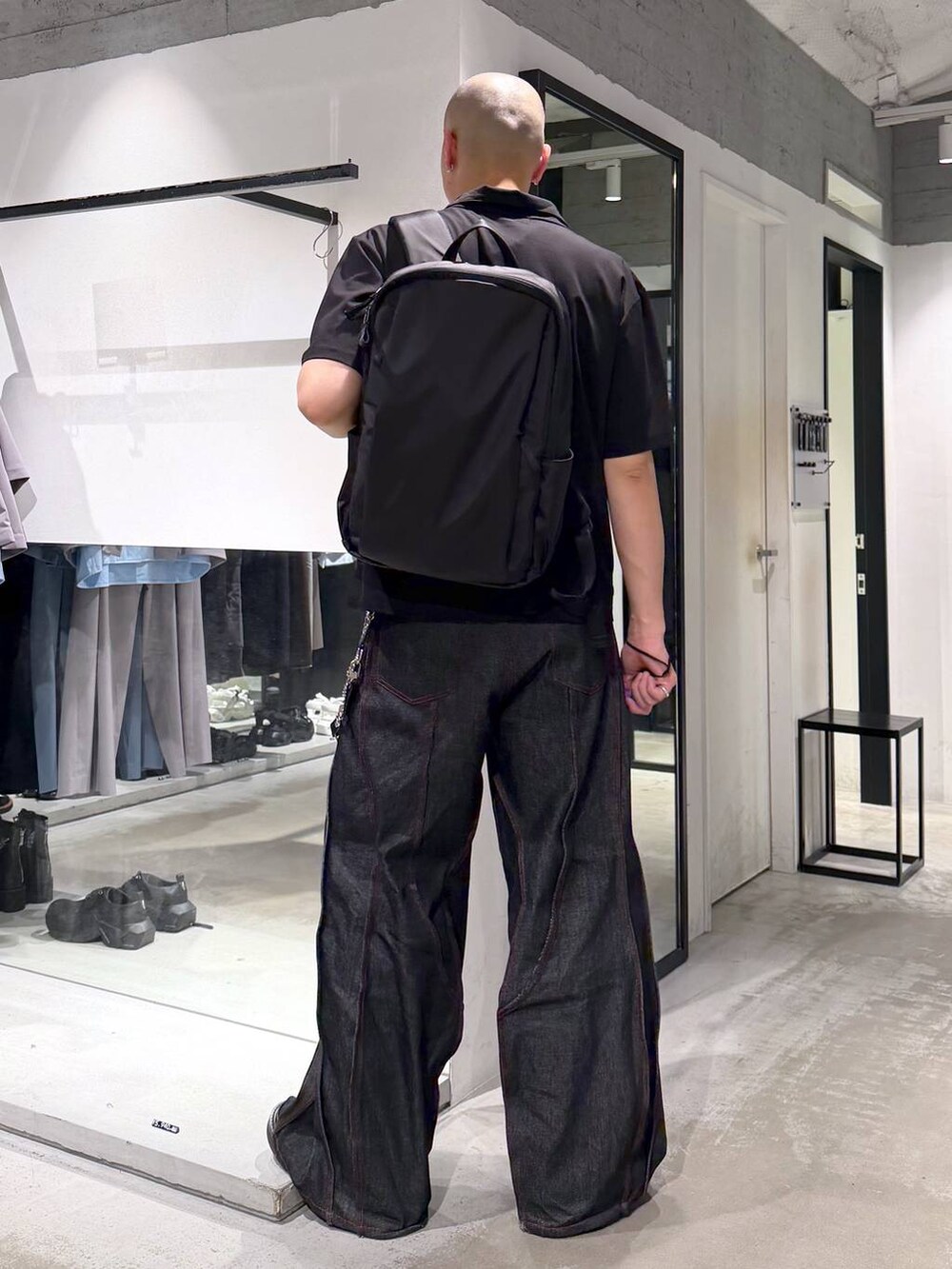 ブラック系のデニムパンツ、パープル系のTシャツ/カットソー、ブラック系のバックパック/リュックを着用したメンズの夏コーディネートの4枚目の写真