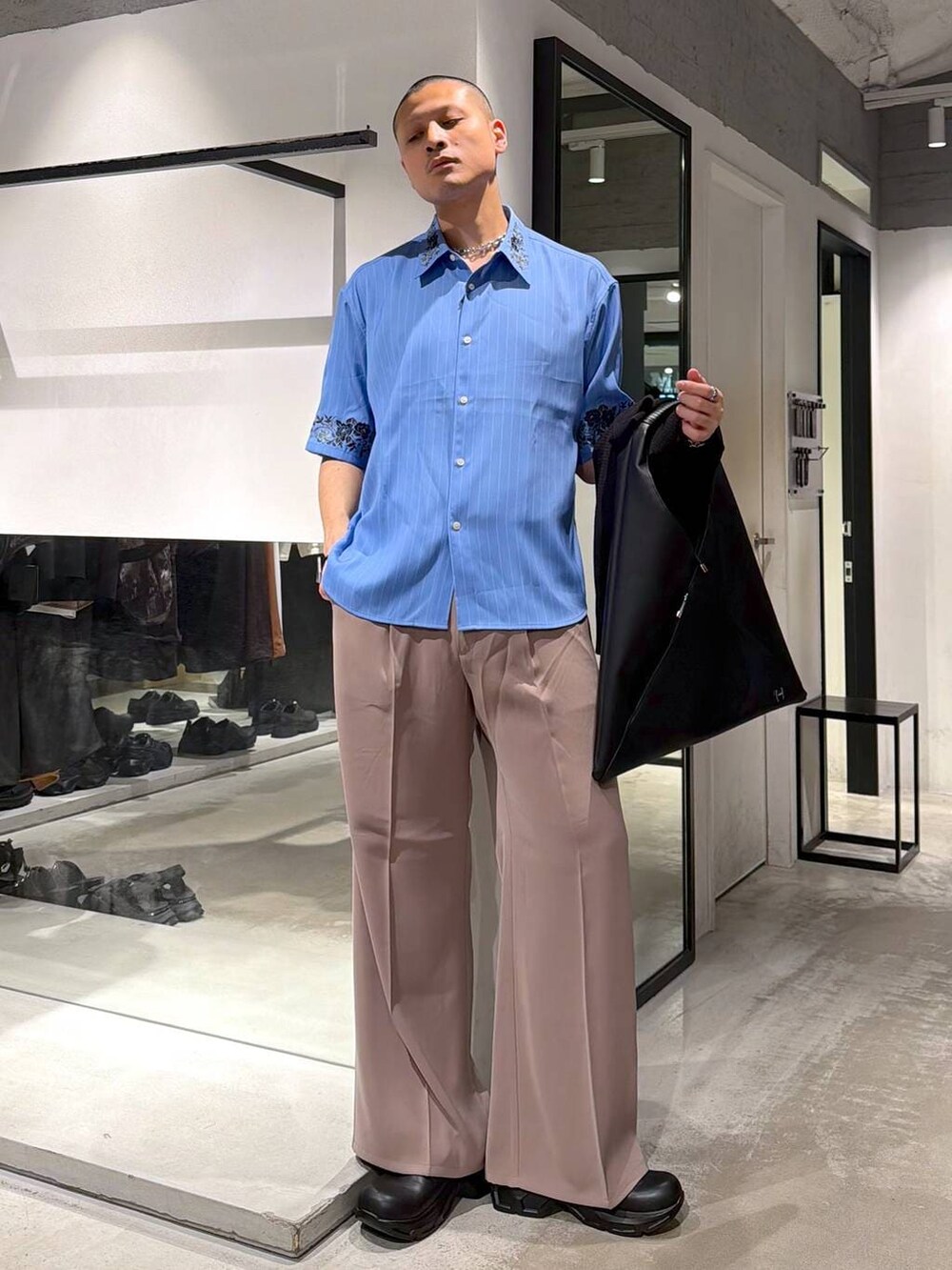 ピンク系のスラックス、ブルー系のシャツ/ブラウス、ブラック系のドレスシューズを着用したメンズの春コーディネートの5枚目の写真