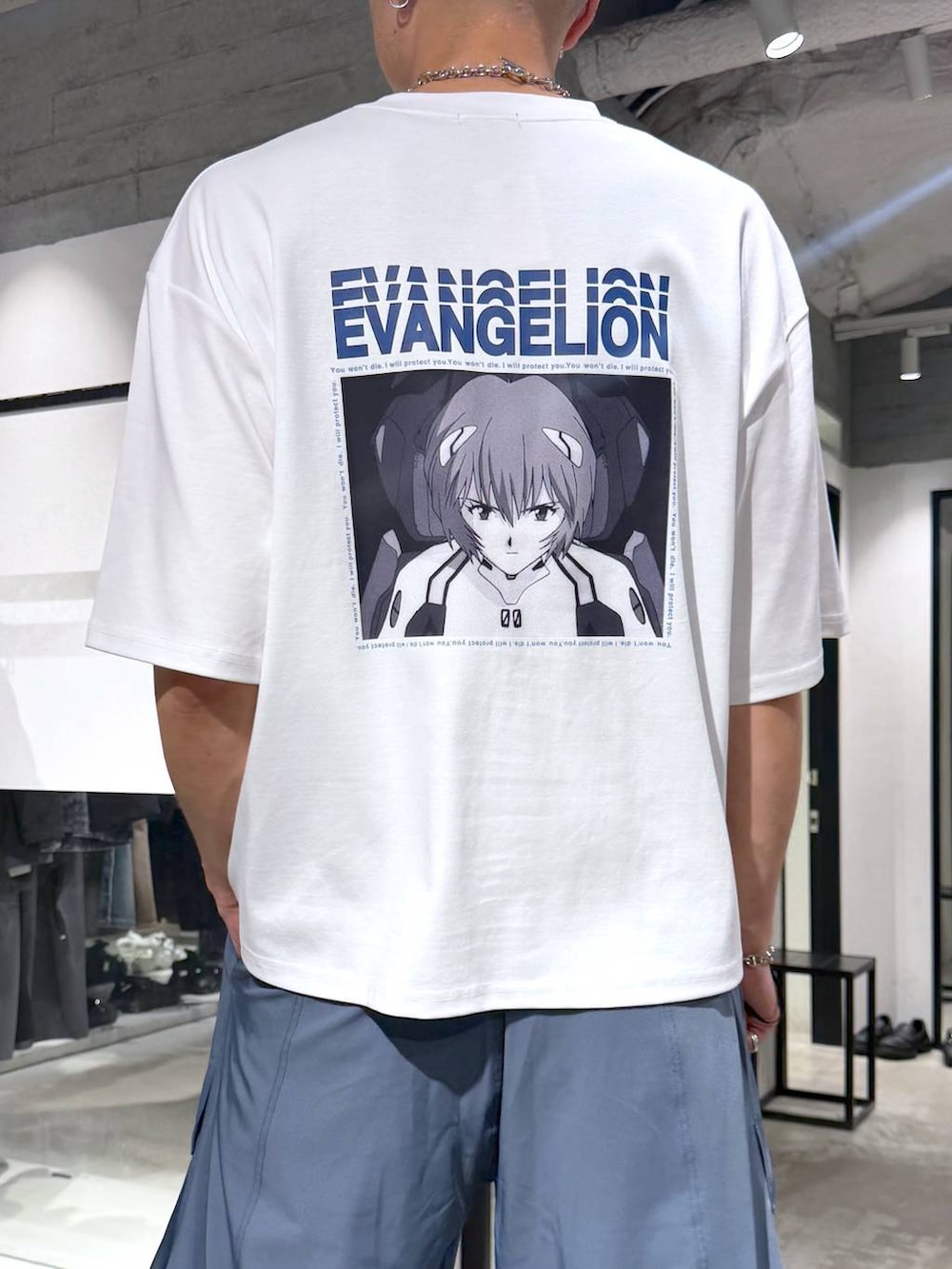 ホワイト系のTシャツ/カットソー、ブルー系のカーゴパンツ、ブラック系のサンダルを着用したメンズの夏コーディネートの6枚目の写真