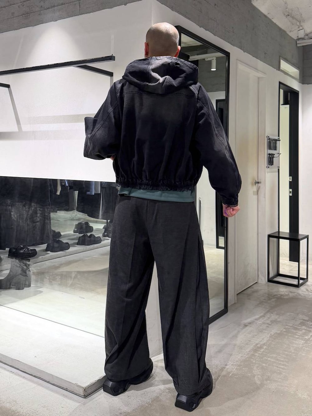 ブラック系のスニーカー、ブラック系のブルゾン、ブラック系のスラックスを着用したメンズの春コーディネートの3枚目の写真