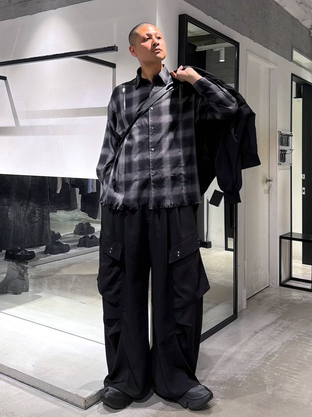 ブラック系のカーゴパンツ、ブラック系のショルダーバッグ、ブラック系のシャツ/ブラウスを着用したメンズの春コーディネートの5枚目の写真