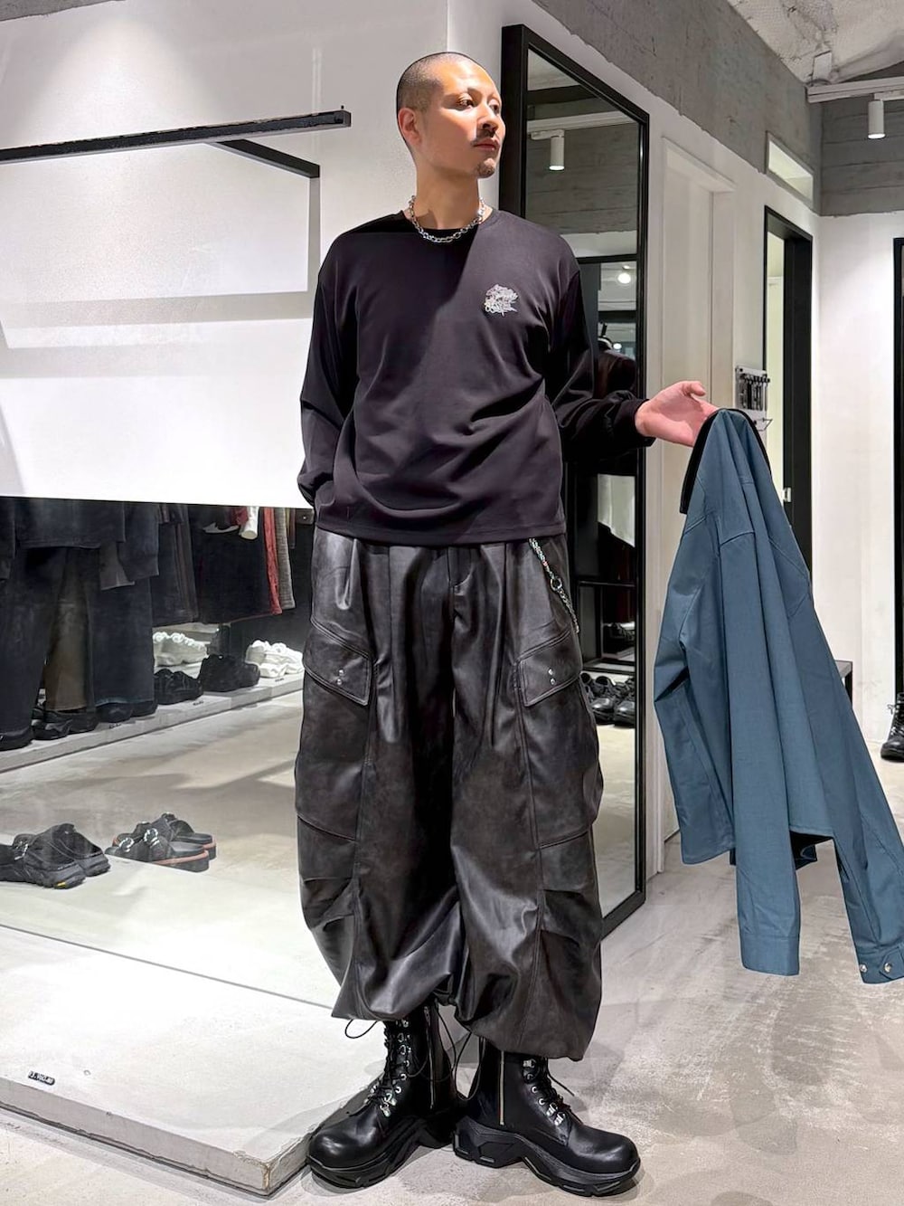 グリーン系のシャツ/ブラウス、ブラック系のブーツ、ブラック系のTシャツ/カットソーを着用したメンズの秋コーディネートの6枚目の写真