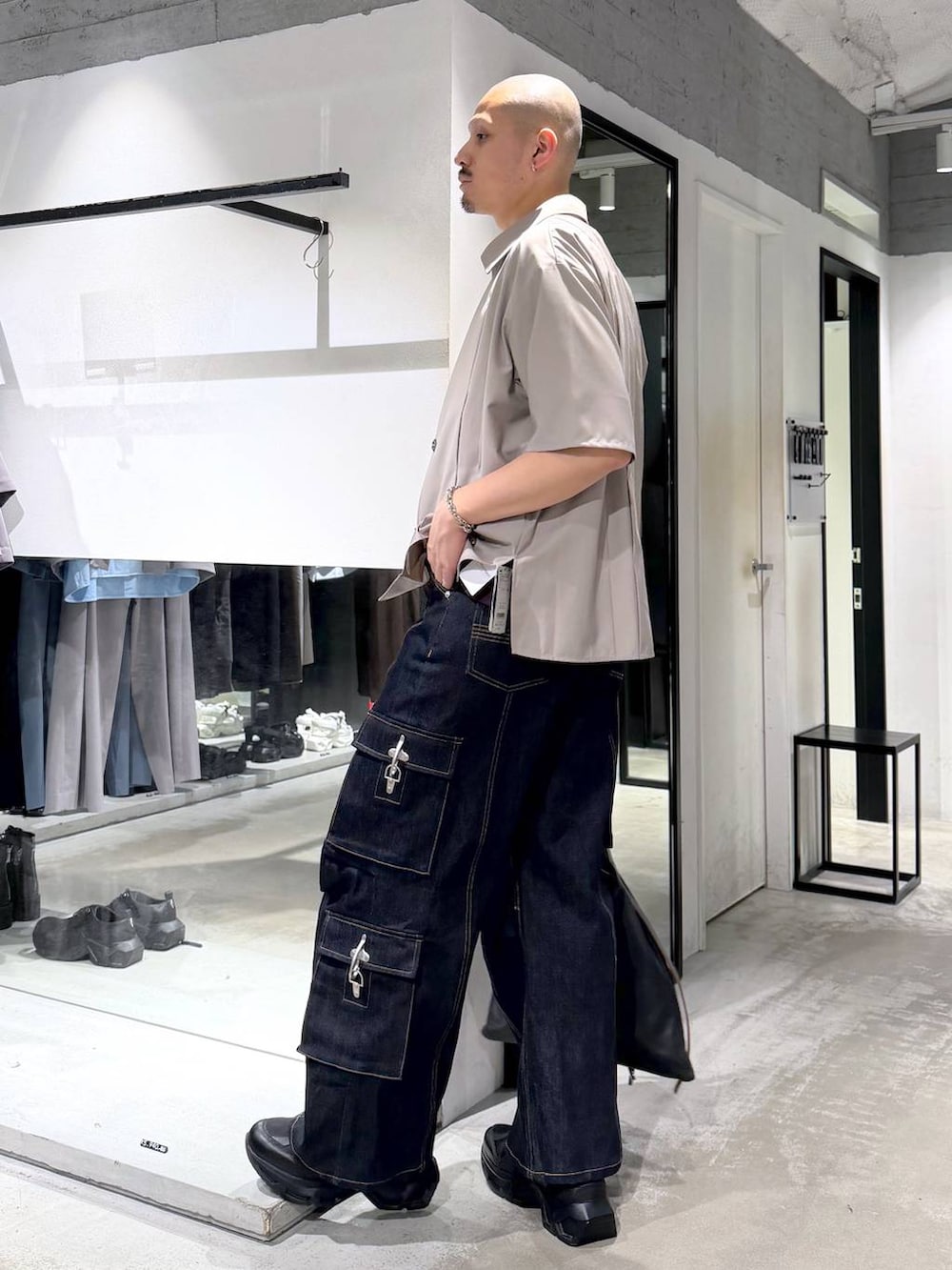 ブラック系のスニーカー、ブルー系のデニムパンツ、ブラック系のトートバッグを着用したメンズの夏コーディネートの2枚目の写真