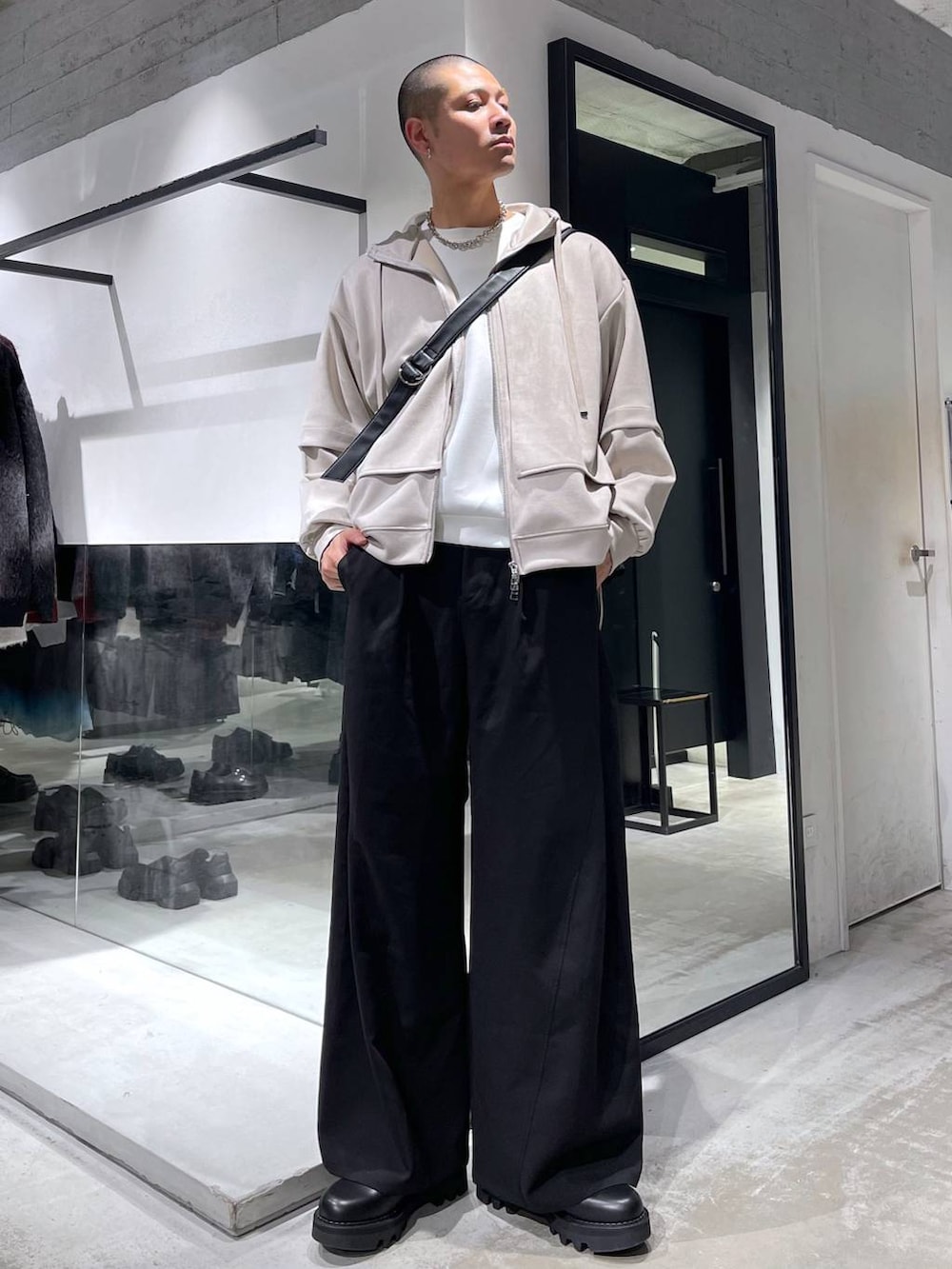 ブラック系のスラックス、ブラック系のショルダーバッグ、ブラック系のドレスシューズを着用したメンズの冬コーディネートの4枚目の写真