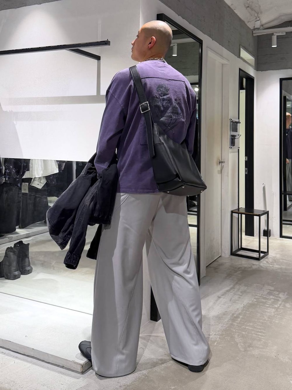 ブラック系のブルゾン、グレー系のスラックス、ブラック系のショルダーバッグを着用したメンズの春コーディネートの5枚目の写真