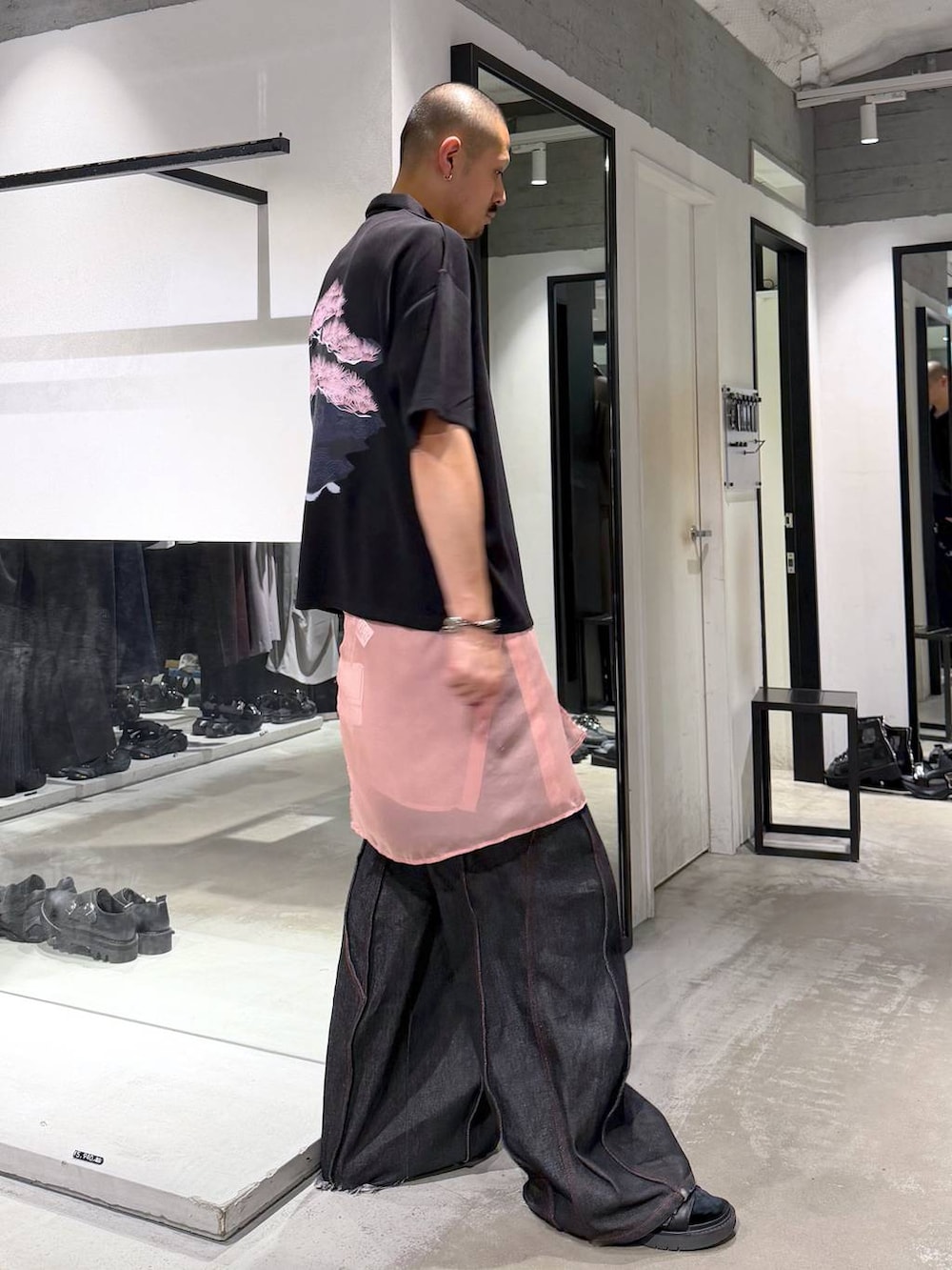 ブラック系のTシャツ/カットソー、ブラック系のデニムパンツ、ブラック系のサンダルを着用したメンズの夏コーディネートの3枚目の写真